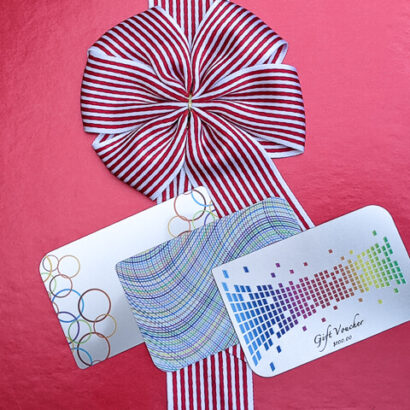 Gift voucher and promotional cards with festive red and white ribbon from puremetalcards.com