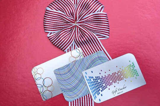 Gift voucher and promotional cards with festive red and white ribbon from puremetalcards.com