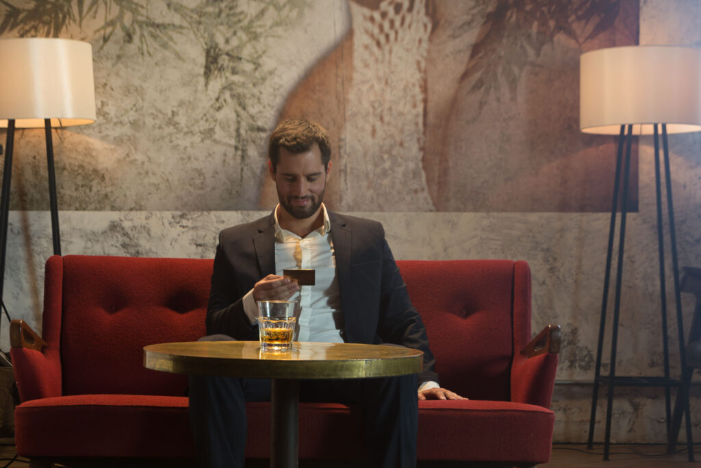 Man in suit holding a gold metal card, reflecting brand identity