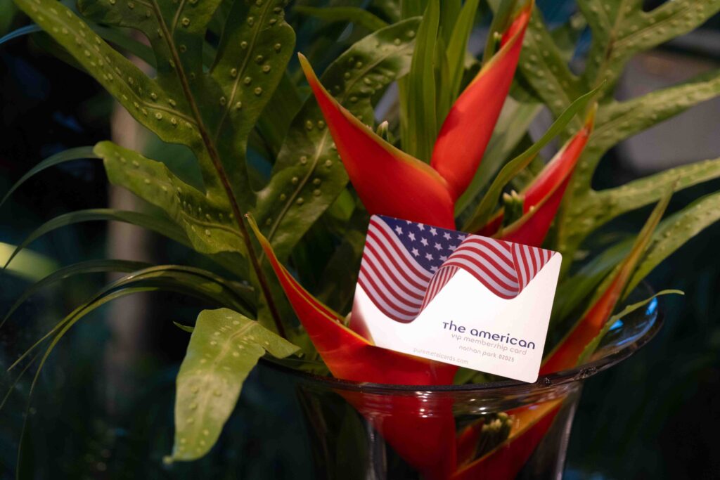 The American VIP membership card with US flag design, reflecting brand identity, in a floral arrangement.