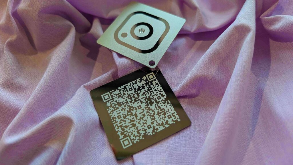 Two mirror metal cards: one with an Instagram logo, the other with a QR code.