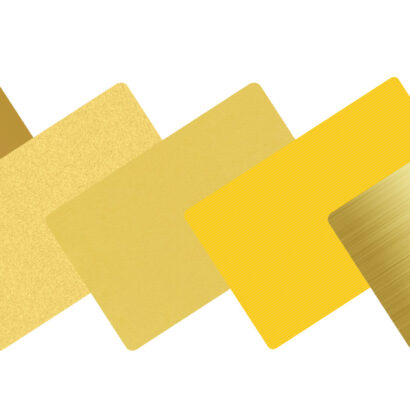 Five blank metal cards in gold tones, showcasing various finishes.