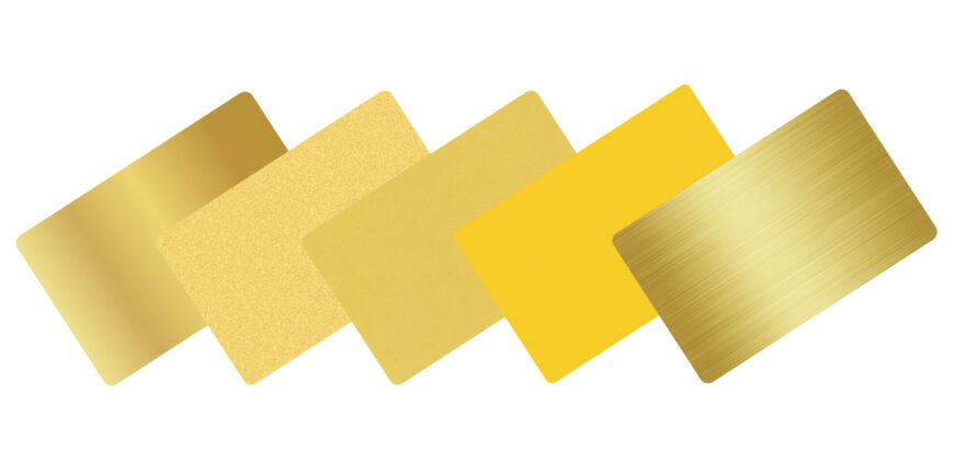 Five blank metal cards in gold tones, showcasing various finishes.