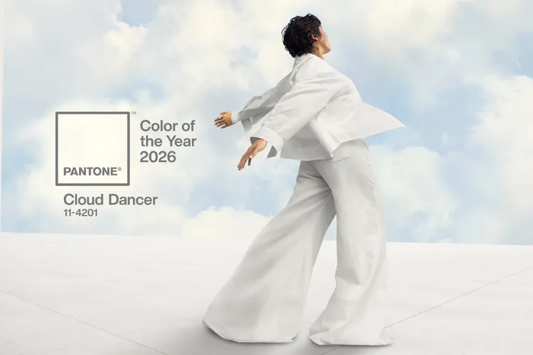 Pantone Color of the Year 2026, "Cloud Dancer," shown with a person in a white suit against a sky backdrop.